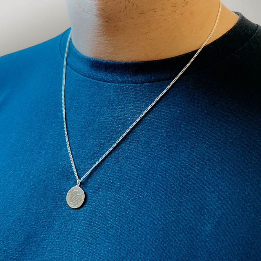 a sterling silver necklace symbolic for strength around a man's neck